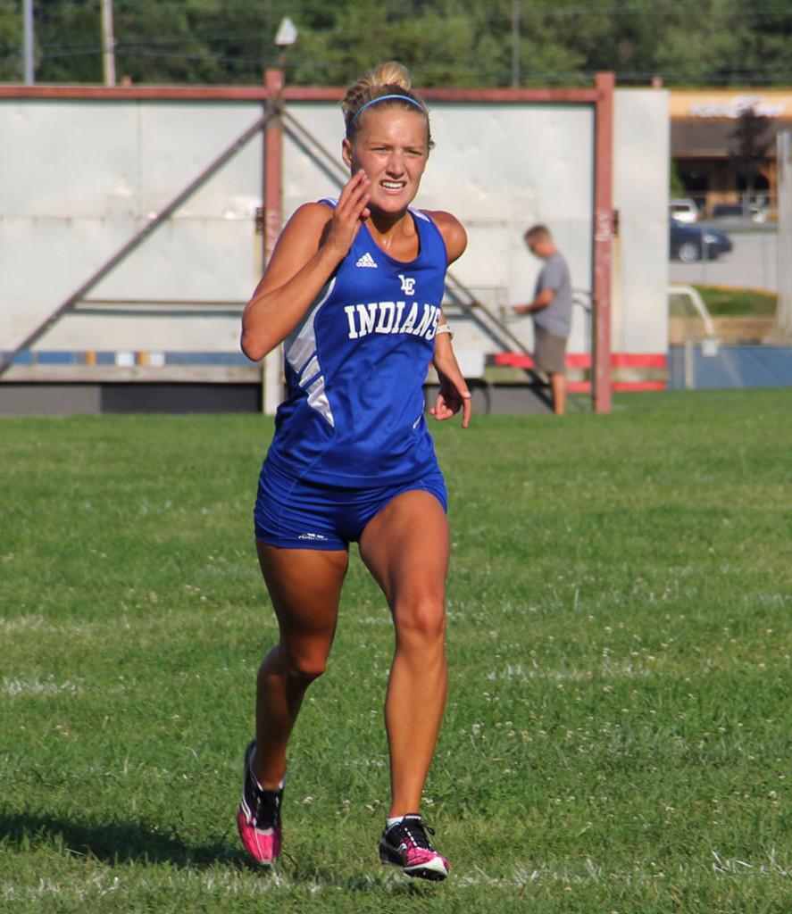 Alaina+Willis+%2812%29+strides+toward+the+finish+line+with+all+her+might+at+the+cross+country+meet+Tuesday.+