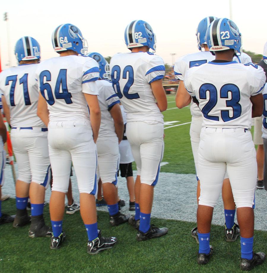 Members of the varsity football team stare at the action on the field. The team defeated East Chicago Central 49-6 on Friday.