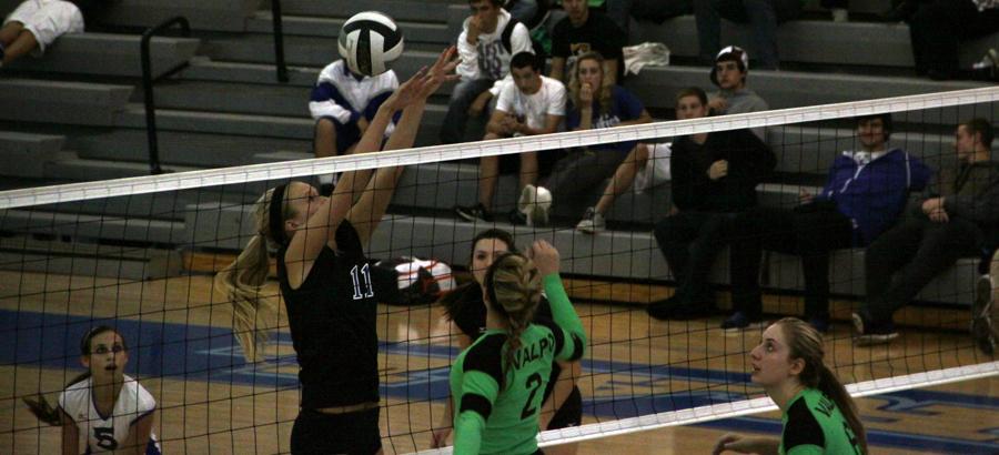 Megan Malantestinic (11) attempts to block a spike hit by a Valpo opponent. Taylor Ellis (10) and Julianne Epperson (12) covered Malantestinic and scored a point for LC.