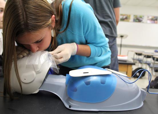 Elissa Fife (12) breathes into a mannequin during a CPR procedure. Being assigned a partner, the second person alternated to also practice CPR when the first person completed a perfect rescue.