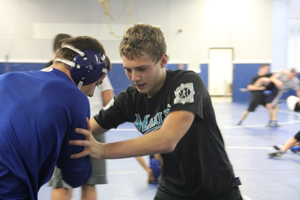 Bryan Tunis (9) practices live wrestling during wrestling practice after school. The team practices together in the upper room over the gymnasium after they run in the hallways.
