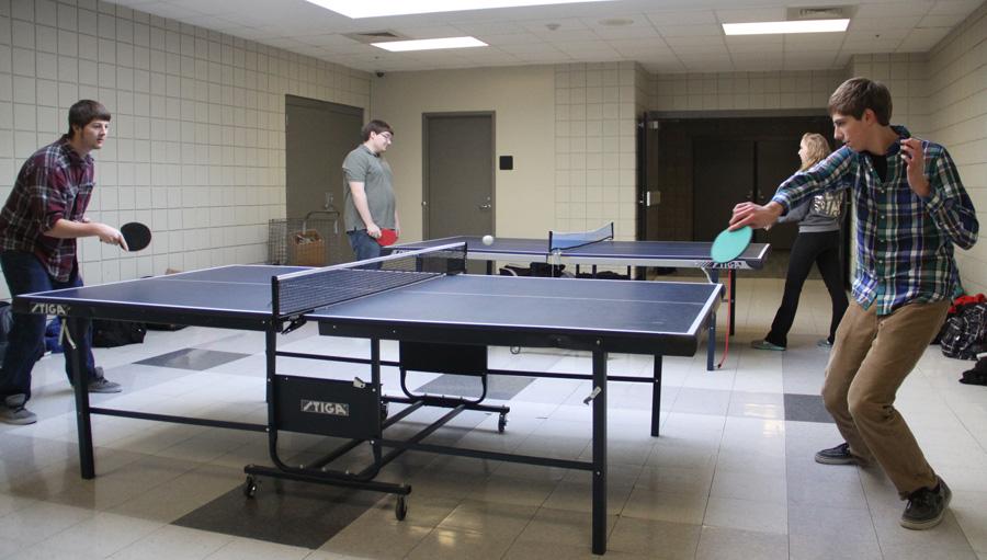 Peter Boyd (12) hits a backhand to Eric Forbes (12) during their intense game of table tennis, while Tracilyn Muszalski (11) plays Daniel Fox (12) on the behind table.  Mrs. Joan Loden, Math, started the club four years ago with some of her Calculus students. 