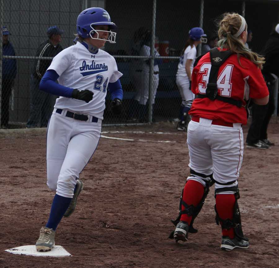Christine Addison (11) crosses home plate after hitting a single and being advanced by her teammates.  Addison scored the second out of three runs for the game.