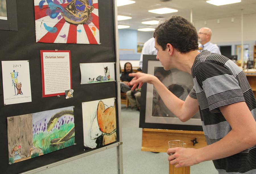 Brennan Hunt (‘12) examines the artwork of Christian Danner (12) while attending the AP 2D and 3D Studio Art Senior Art Show.  As a Lake Central AP Art alum, Hunt came to show his support for his old art program.