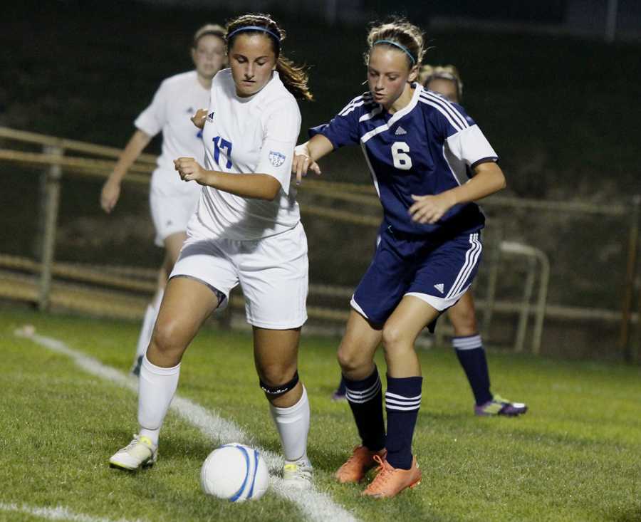 Ashley Halterman (12) faces off with a Michigan City opponent for the ball. The play led to one of the many shots taken on the Wolves that night. 