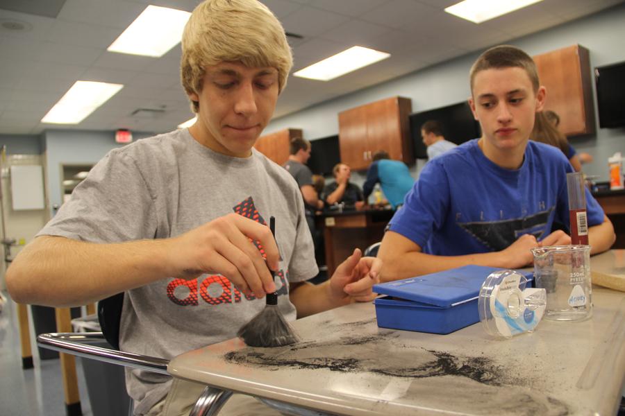 Michael Heuberger (12) dusts his desk in carbon powder in order to reveal fingerprints underneath.  The forensics class students were allowed to find their own fingerprints on any hard, non-porous surface.