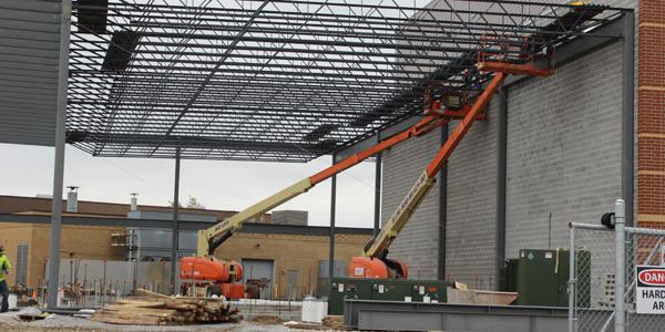 Construction workers apply the steel against the brick wall of the academic wing.  The installation is planned to be finished on Nov. 8.