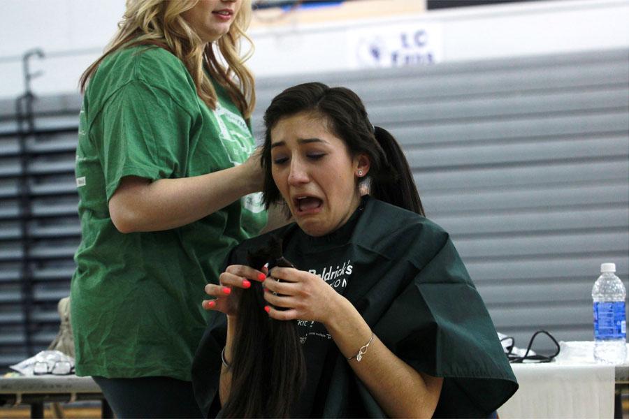 Alayna Prisby (11) looks in amazement at her first cut pig tail.  Prisby raised over $3,400 for the organization.