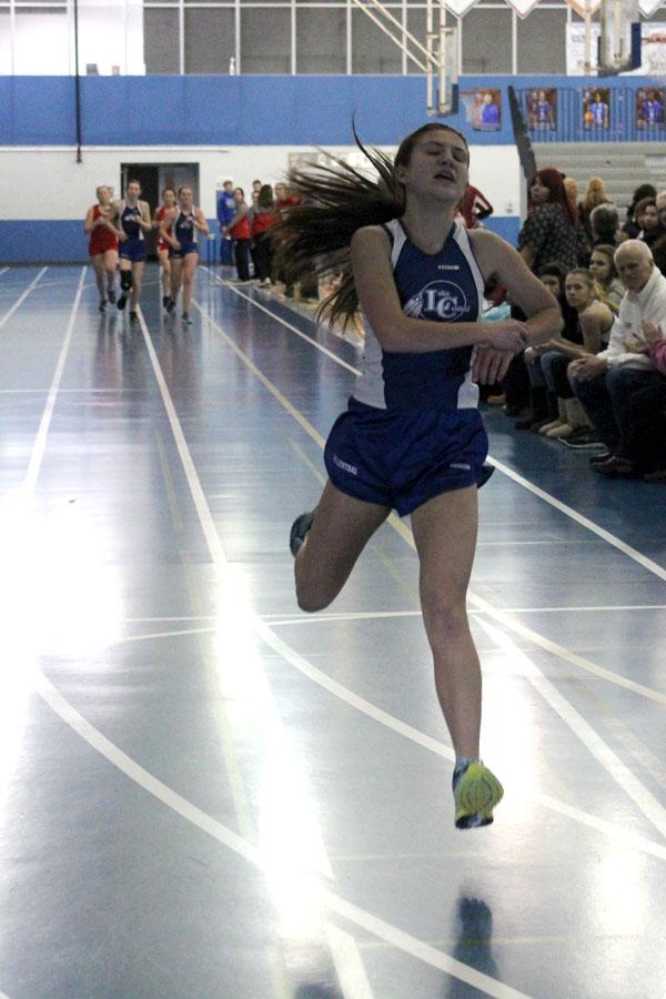 Sarah Hunsley (9) crosses the finish line in the 3200 meter race. She was the first runner to come in. 