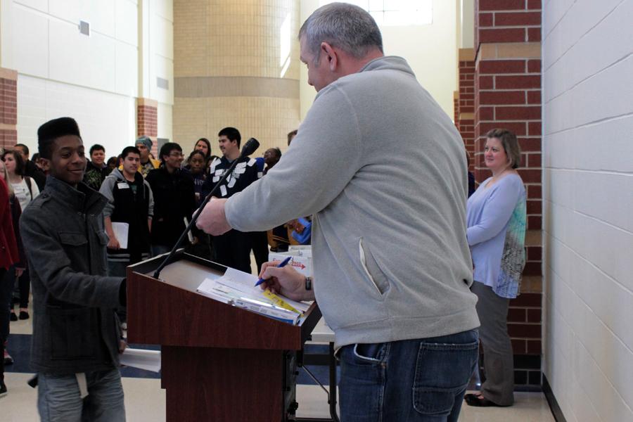 A Gavit student goes to the podium to receive his prize from Mr. Sean Begley.  If students attended all four presentations before lunch, their card was entered into a drawing for a chance to win a variety of prizes ranging from gift cards to backpacks.