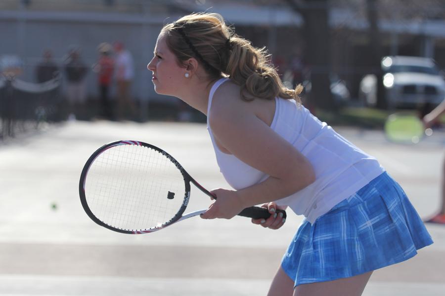 Emily Birlson (11) stays focused as her partner, Sarah Dingman (11) serves.  Birlson has played on the tennis team all three years of her high school career.