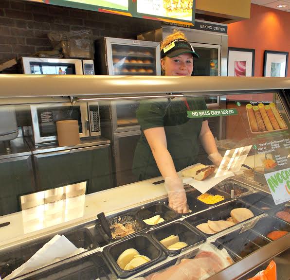 Ariel Lara (12) helps a customer during her shift. She previously wiped down the  tables in the dining area. 