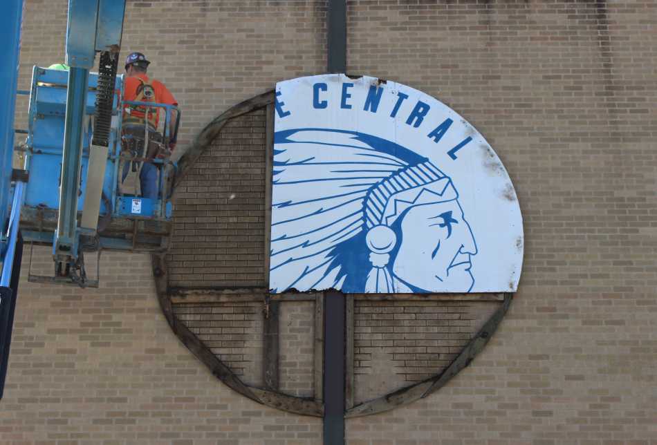 Construction workers take down the Indian Head. The Indian head was once on the front of the Field House. 
