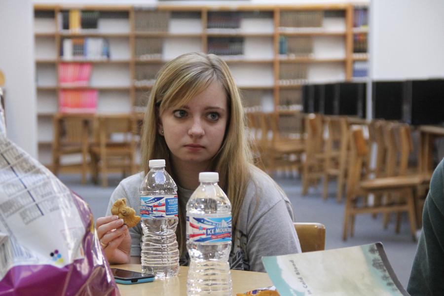 Chelsey Schmock (11) listens while eating a cookie.  The meeting on Oct. 26 was Schmock’s first book club meeting.
