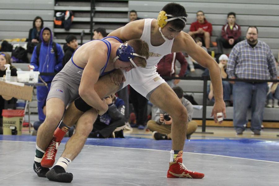 Kodie Christenson (12) controls his opponent’s leg during the championship match.  Christenson was the 152-pound weight class champion.