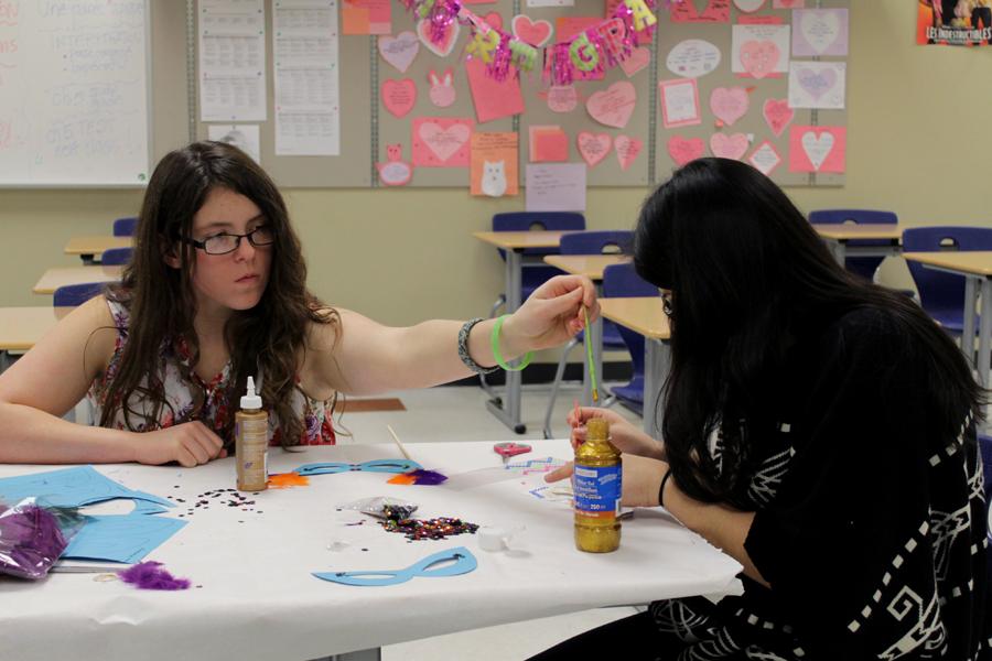 Sarah Diviney (11) and Leslie Lopez (11) concentrate on decorating their Mardi Gras masks. The end of Mardi Gras marked the beginning of the religious fasting, Lent.
