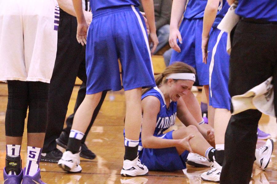 Gina Rubino (12) falls to the ground with a knee injury.  Rubino was walked off the court with assistance. 