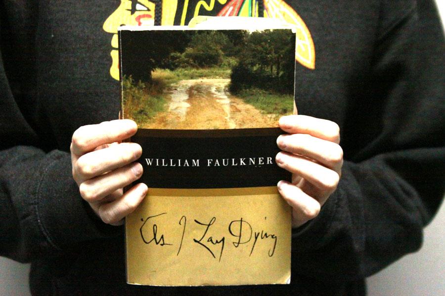 A student holds her copy of “As I Lay Dying” by William Faulkner. Students were assigned this book to read for their AP English 11 class. 
