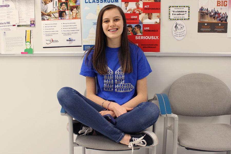 Hailey Phelps (10) wears her Young Life t-shirt while sitting on a chair in the hallway.  She got the t-shirt from the group, which usually met on Wednesdays.  