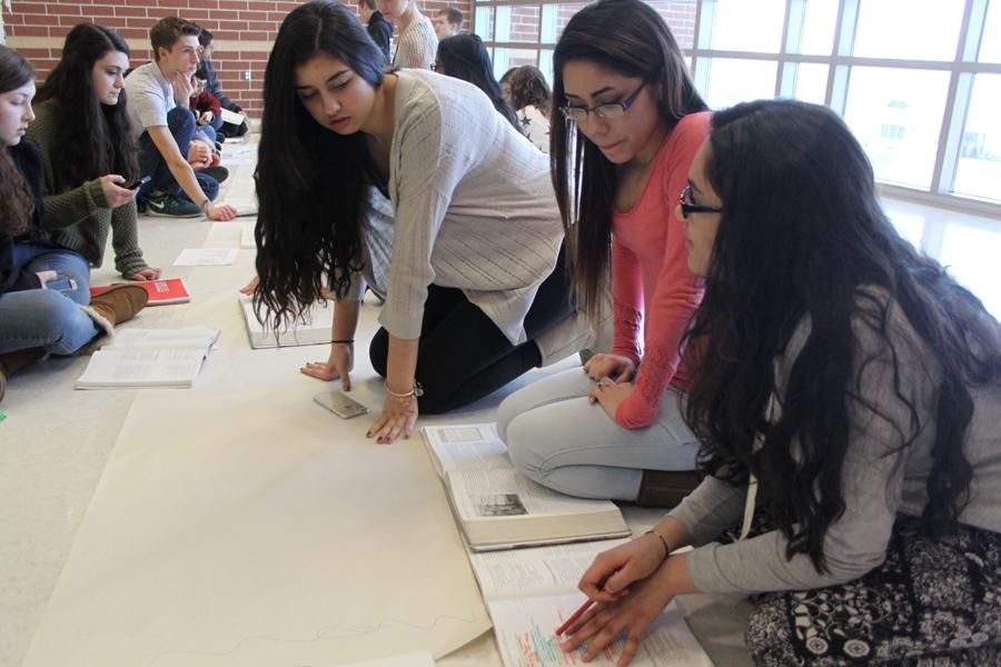 Linda Morton (10) Dalia Rodriguez (11) and Niji Shah (11) collaborate on what they are going to draw on the blank piece of paper in front of them. The decade that they were assigned was the 1920s. 