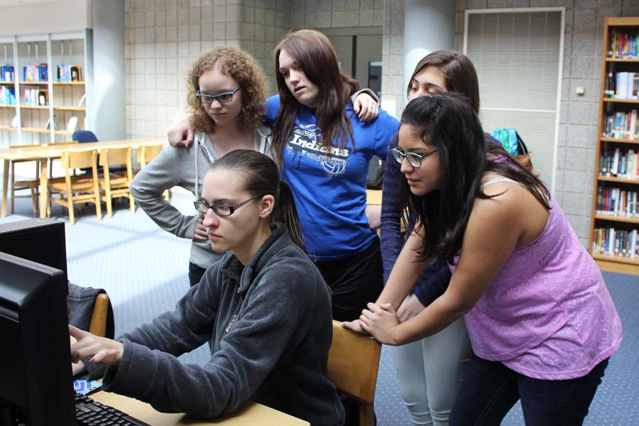 Katherine Veronesi (10), Rachel Streck (10), Diana Bolanos (10) and Erica Guevara (10) gather around Miss Rebekah Lamb, West Lake, as she shows them an online sign language resource. Veronesi, Streck, Bolanos and Guevara played a game to practice fingerspelling while visiting the website.