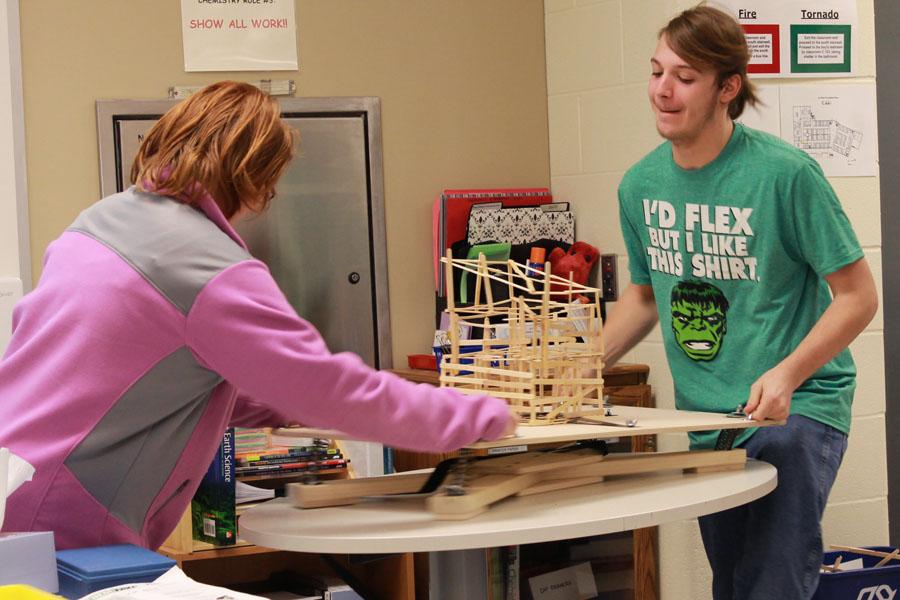 David Davis (10) and Samantha Rusch (10) shake the popsicle stick building to simulate earthquake movement. This lab required students to learn about building safety.
