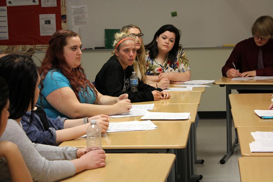 Alisha Donovan (12) defends her side of the debate as her teammates listen. The debate was organized so the students had to research the topic before they were able to give an opinion.