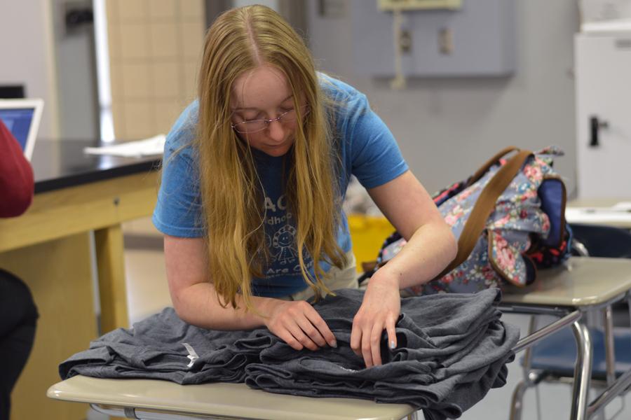 Ashley Millette (12) counts the number of shirts that were sold. The club sold the shirts to honor Earth Day.
