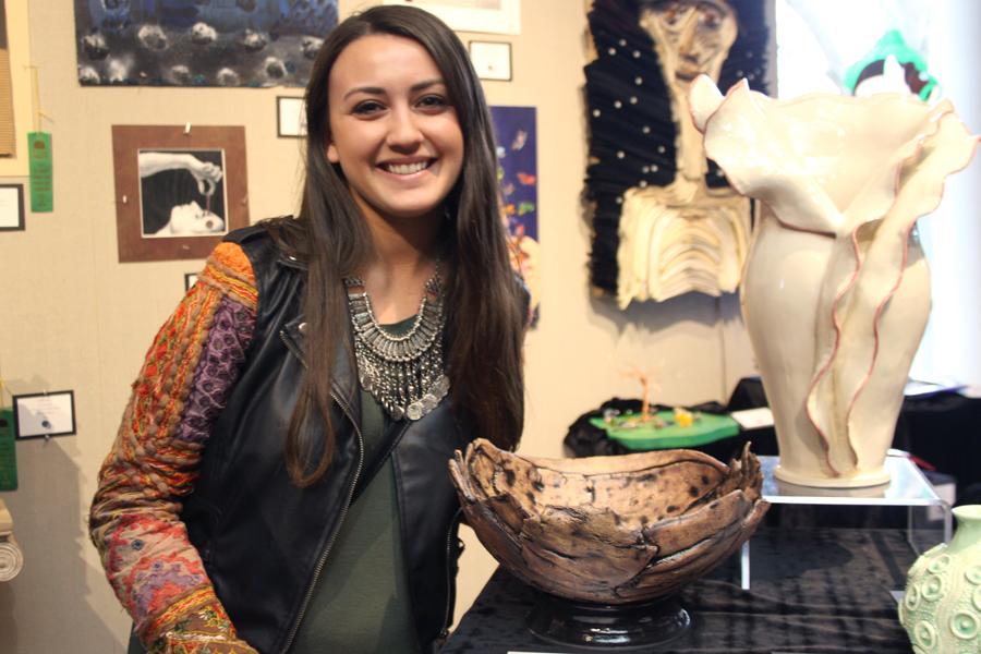 Brianna Cassidy (12) smiles next to her ceramic bowl “Unrefined.” Out of all schools that participated, she won the Best Ceramic award.