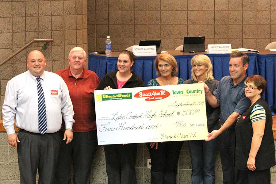 Four members of the school board and three representatives from the St. John location of Strack and Van Til hold a check for $500. The money was donated to Lake Central High School to promote education.