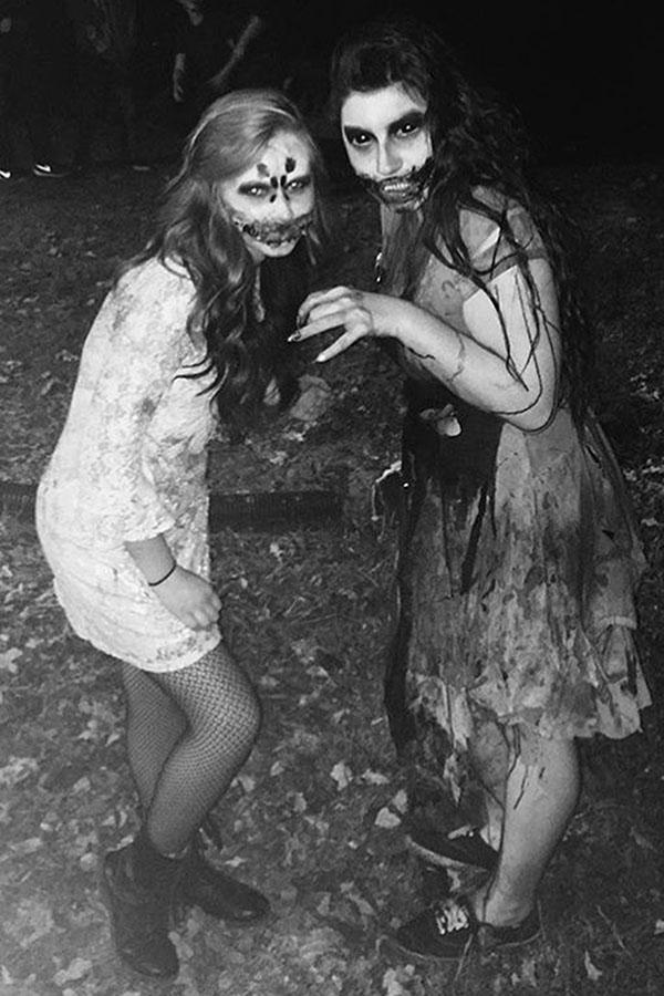 Megan Eierman (11) and Alyssa Raymond (10) pose in their costumes while working at Lake Hills Haunted House. Both students participate in the haunted house for fun.