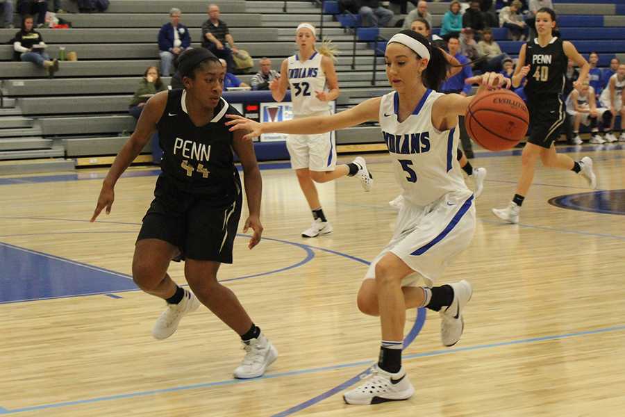 Victoria Gard (12) tries to block her opponent while dribbling the ball. Gard passed the ball to one of her teammates. 