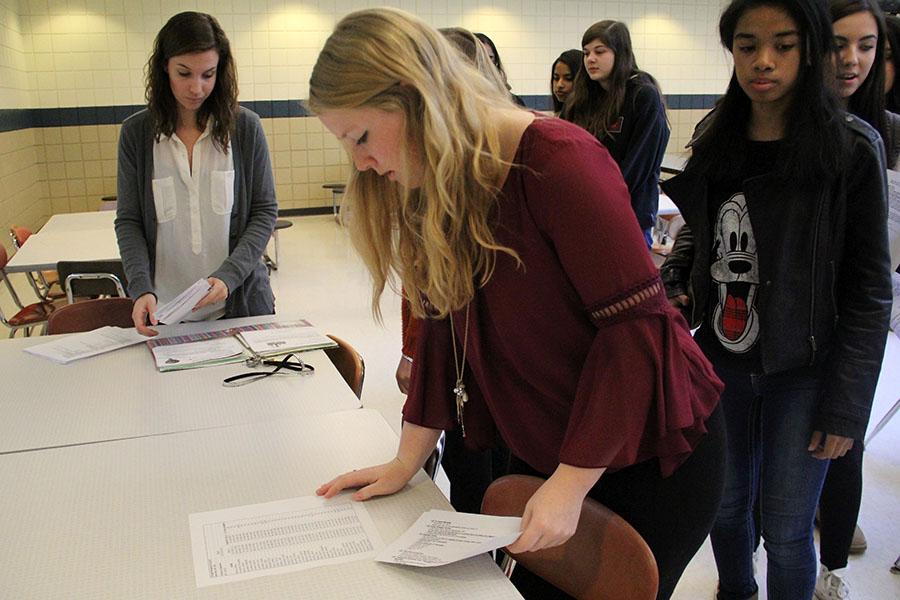 Members of N-Teens line up to check their name on a list. The paper listed all students signed up to go on the Chicago trip which will take place on Saturday, Dec. 5.