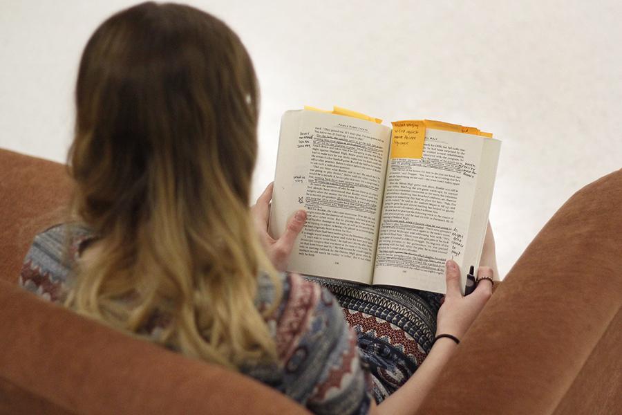 A student reads and annotates “Friday Night Lights” by H.G. Bissinger, which was assigned during class. Some classes are giving students homework to do over the two week winter break.