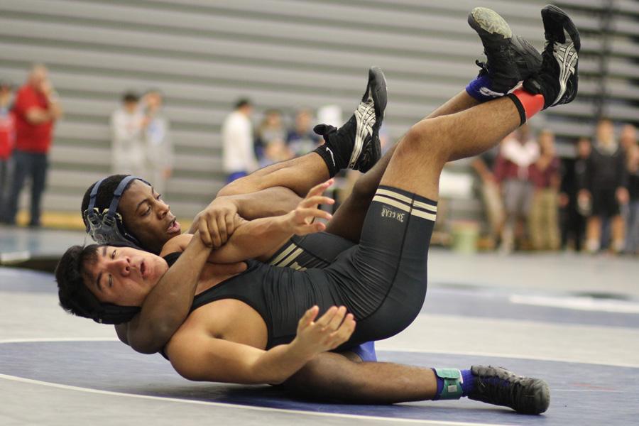 Romel Spight (12) cradles his competitor before pinning him. Spight placed 5th in the 170-pound weight class at the 35th Annual Harvest Classic.