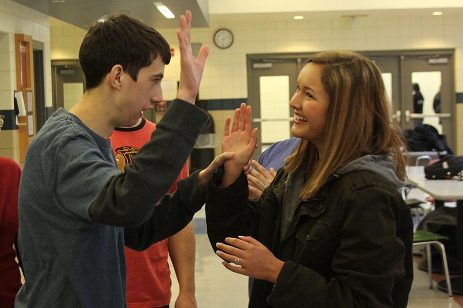 Jack Rogers (11) goes to high-five Madeline Young (12) after playing a game of ‘Simon Says.’ Rogers and Young were partners for all of the activities during the meeting. 
