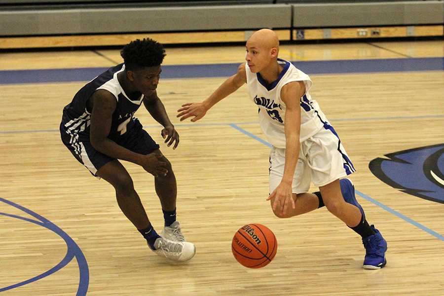 Isaac Beatty (9) sprints down the court with the ball in hand, attempting to help his team win the game. Beatty played on the JV team as a freshman and helped contribute to the team’s final score. 