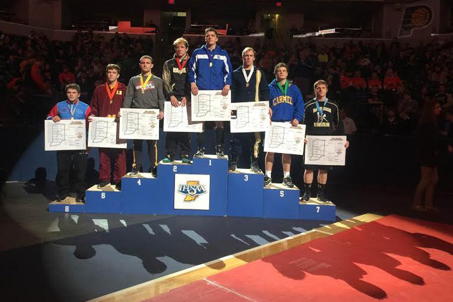 Jacob+Kleimola+%2812%29+stands+at+the+top+of+the+podium+at+the+IHSAA+State+Finals.+Kleimola+received+a+gold+medal+and+bracket+for+his+victory.+