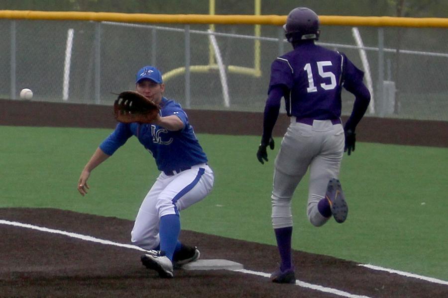 Jake Wisniewski (12) attempts to catch the ball to get the Merrillville runner out at first. The Indians only gave up one hit throughout the game.