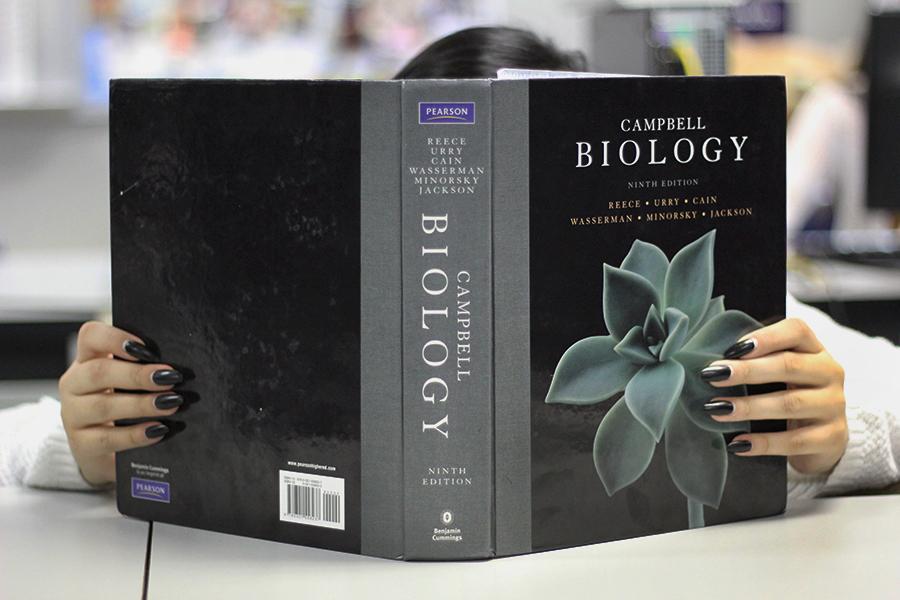 A student dives deep into her AP Biology textbook and studies before going to the AP conference. The conference takes place at Lake Central on April 9 from 7:50 a.m. to 12:40 p.m. 