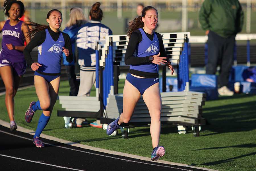 Sara Ramos (11) and Sydney Vandersteeg (11) sprint around the corner of the track.  The Indians won this meet, which took place on April 12 at home against Merrillville and Crown Point. Photo by Stefan Krajisnik
