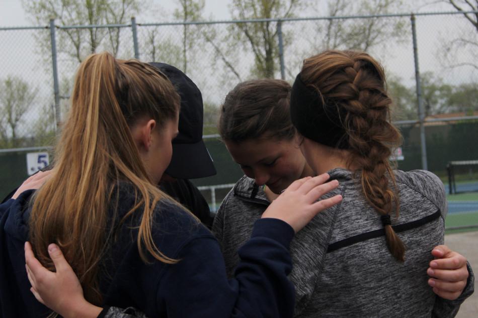 Claire Gronek (10), Lauren Gronek (11), Anna Wachowski (11) and Colleen Quinn (12) gather in a circle to pray before the matches began. A few players do this tradition before every match to lift up their spirits. 
