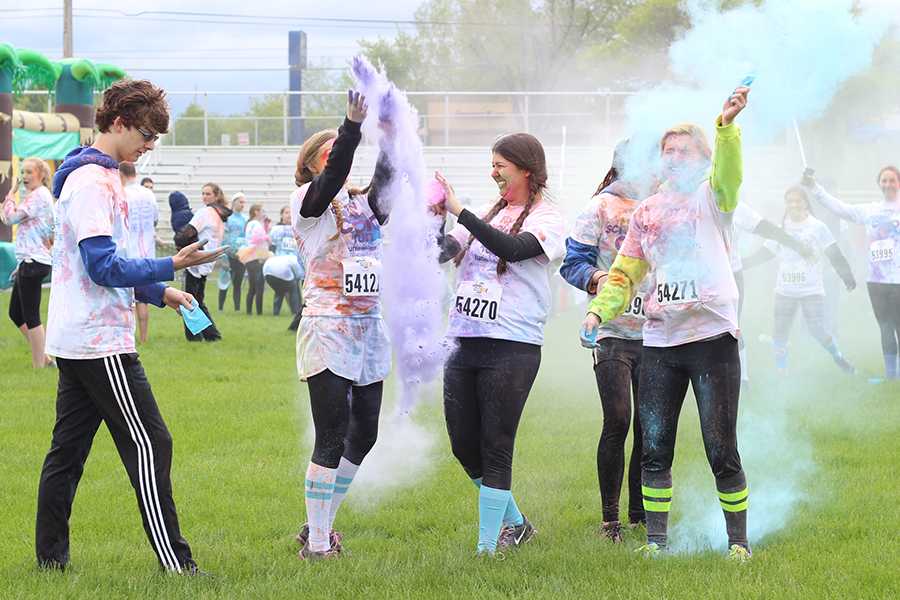 Samuel Michniewicz (11), Autumn Napiwocki (11), Alexa Szatkowski (11), Michelle Buckman (11) and Madelyn Long (11) throw their color packets into the air after the Color Run. Most participants threw packets around at each other after the race for personal enjoyment.  
