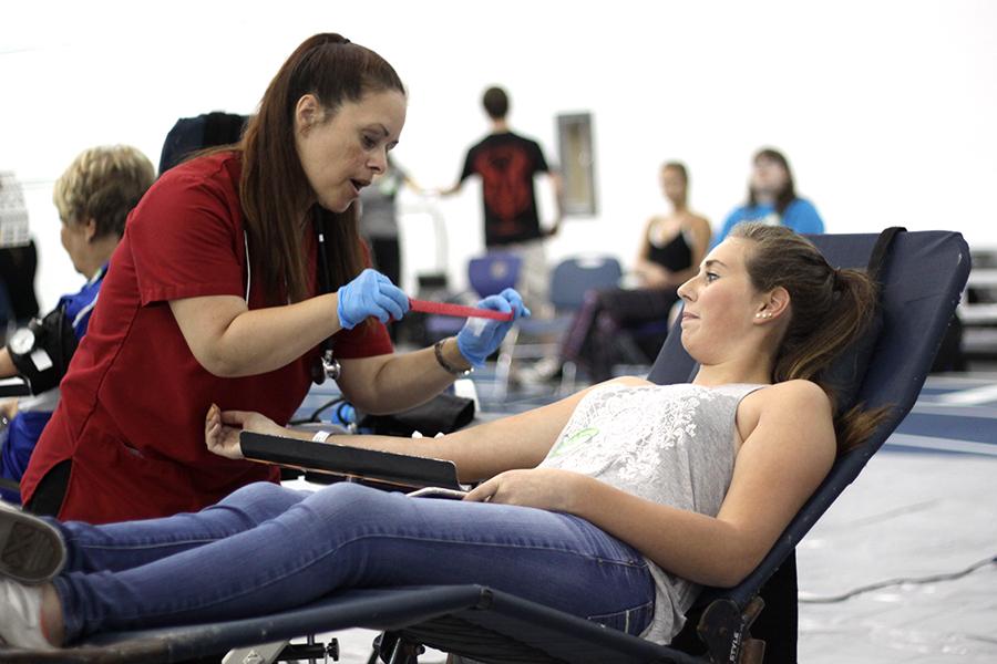 Ashlynne Dransoff (11) watches the nurse wrap her arm. The blood drive took place in the Fieldhouse.
