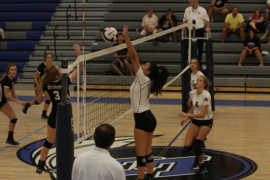 Linda Morton (12) blocks the ball from entering the Indian side. Morton played outside hitter during the game.