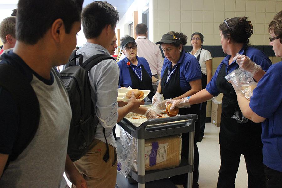 Members of the cafeteria staff hand out chicken sandwiches to students during D lunch. The staff was unable to make lunches because of a sewage problem on Monday, Sept. 26.