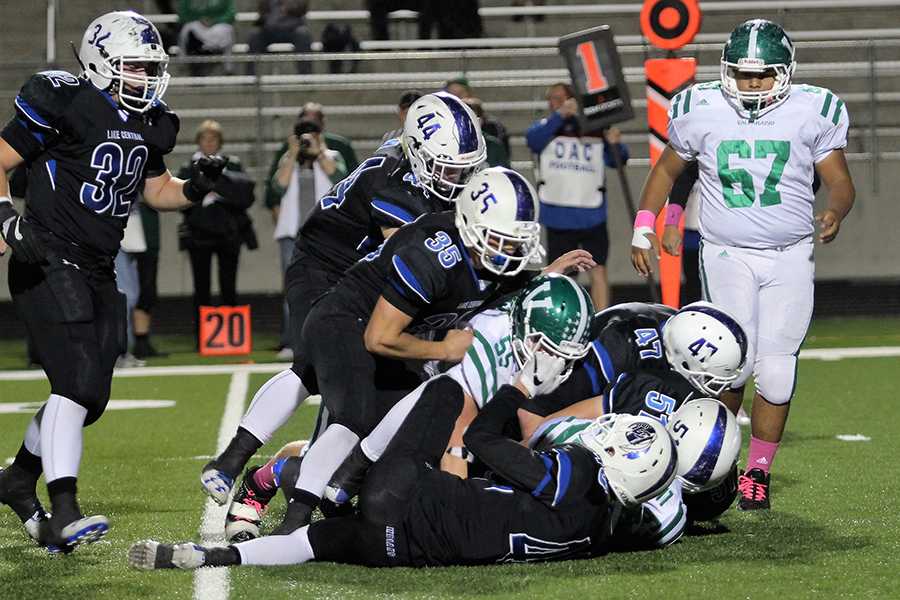 The Indians tackle the Trojans to block them from completing a play. Lake Central won the game with a score of 21-20.
