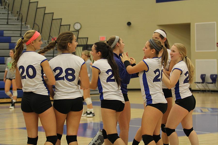 The JV girls volleyball team huddles together before the game. They showed off their skills on the court shortly after.