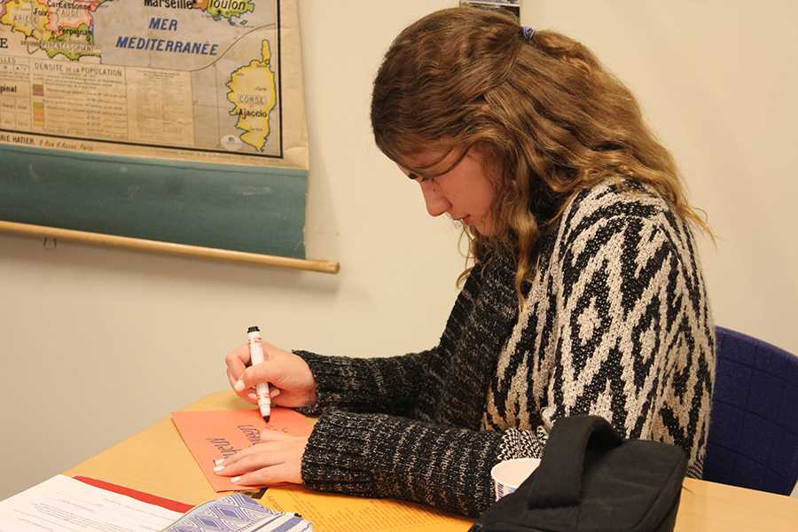 Claire Karberg (10) makes a Halloween themed card at French club on October 25. Students made Halloween themed crafts at the meeting.
