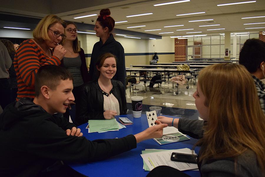 These Campus Life members are playing a card game while waiting for the leaders to announce that the meeting is starting.  The card game was a magic trick that was started by Tony Pacheco (10).
